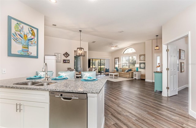 kitchen featuring white cabinets, dishwasher, light stone counters, and sink