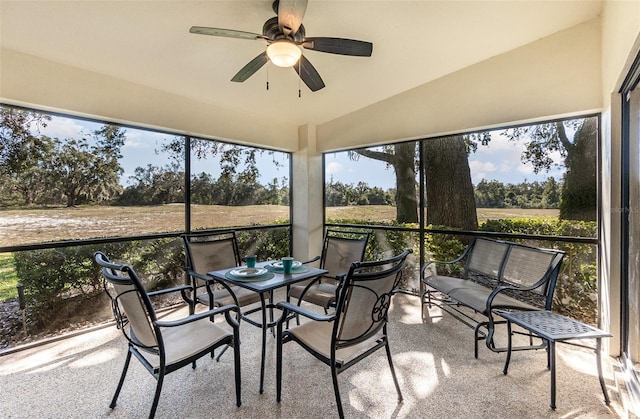 sunroom with ceiling fan and vaulted ceiling