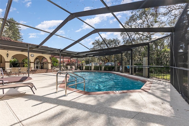 view of pool with glass enclosure and a patio area