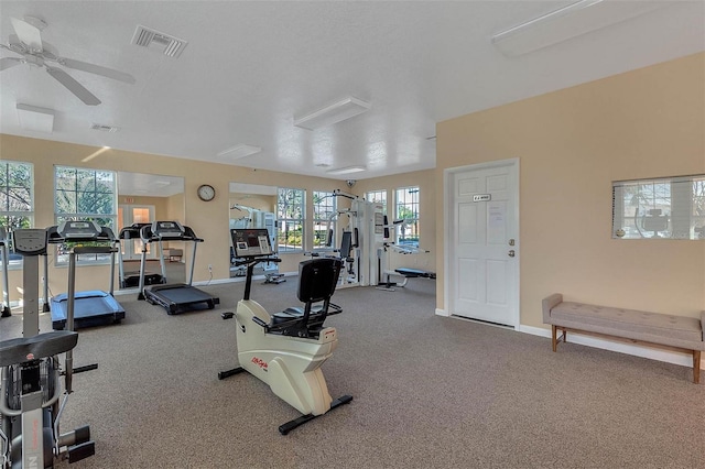 workout area featuring ceiling fan, carpet floors, and a textured ceiling