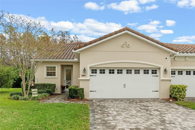 mediterranean / spanish home with a front lawn and a garage