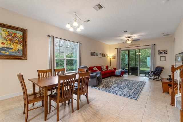 dining area featuring light tile patterned floors and ceiling fan with notable chandelier