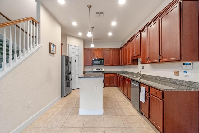 kitchen with a center island, sink, stainless steel appliances, pendant lighting, and light tile patterned floors