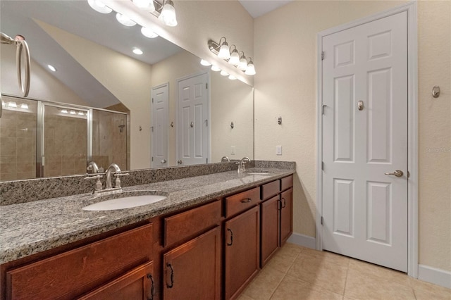 bathroom with tile patterned floors, vanity, and a shower with door