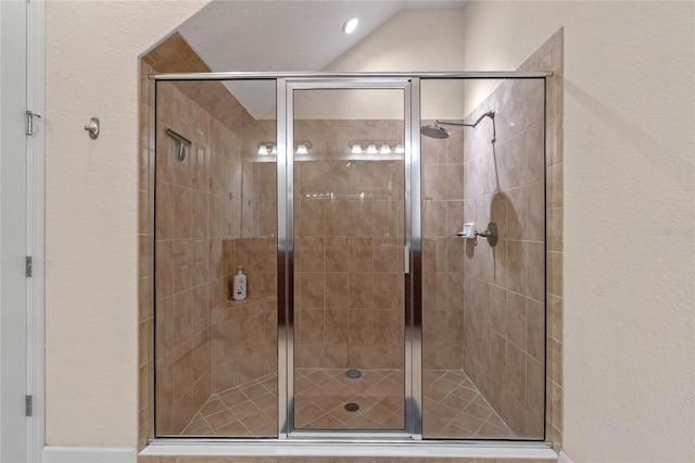 bathroom featuring walk in shower and lofted ceiling