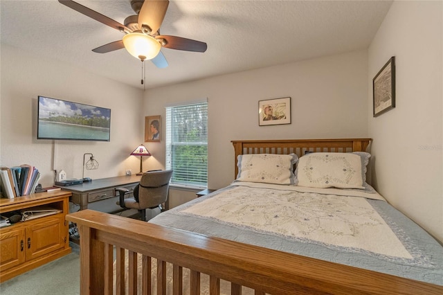 carpeted bedroom featuring ceiling fan and a textured ceiling