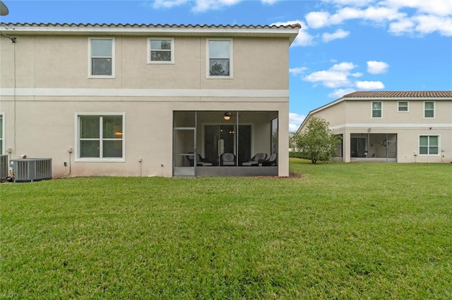 rear view of property with a yard, cooling unit, and a sunroom