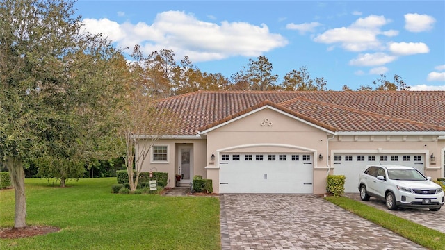 mediterranean / spanish home featuring a front lawn and a garage