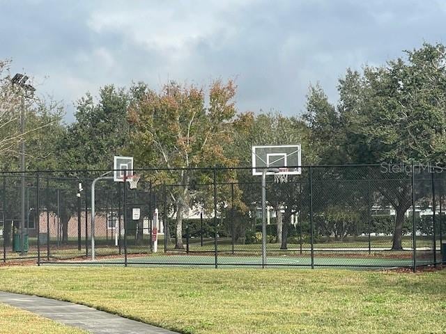 view of sport court with a lawn