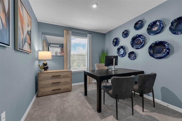 carpeted home office featuring a textured ceiling