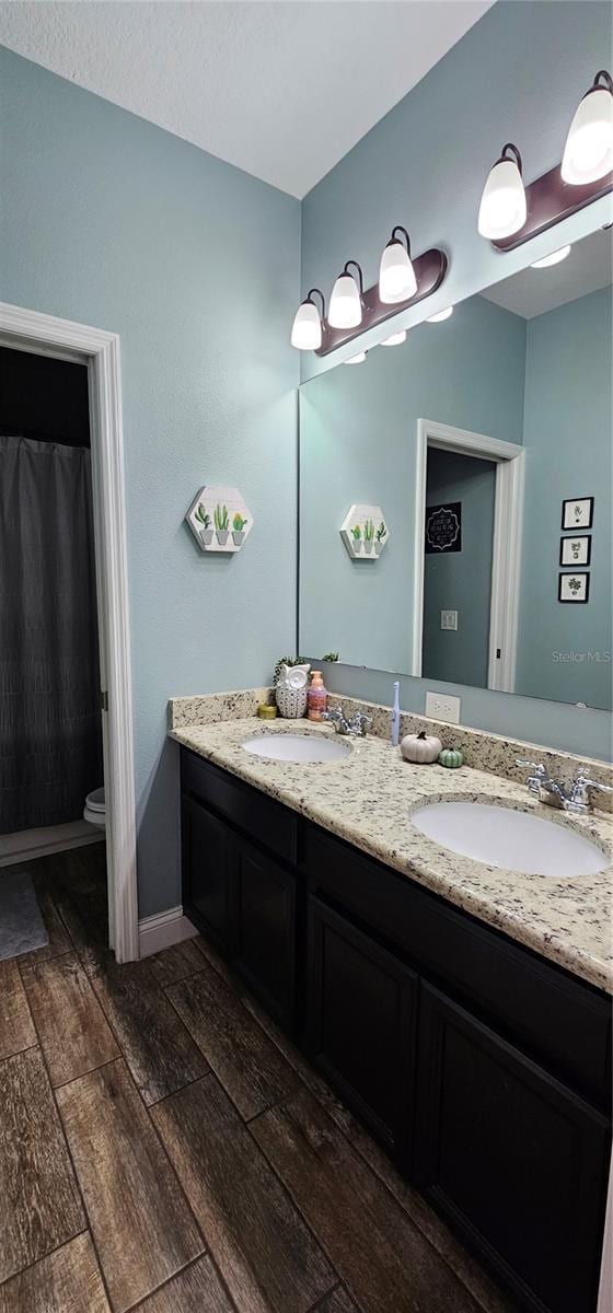 bathroom with hardwood / wood-style floors, vanity, and toilet