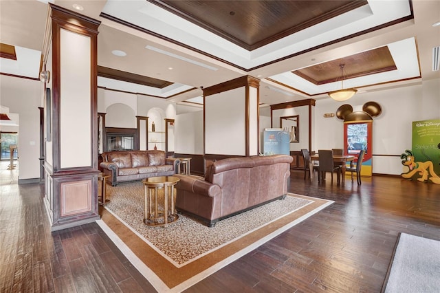 living room featuring dark hardwood / wood-style flooring, crown molding, and a tray ceiling