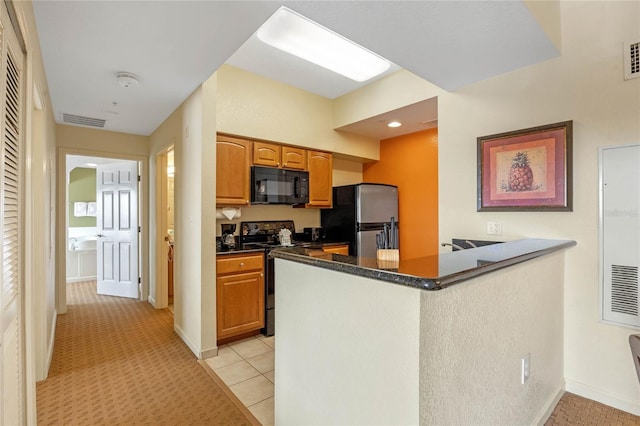 kitchen with light tile patterned flooring, kitchen peninsula, and stainless steel appliances