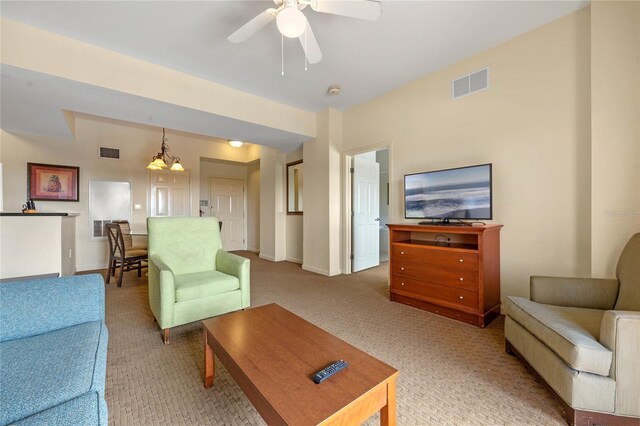 living room with light colored carpet and ceiling fan with notable chandelier