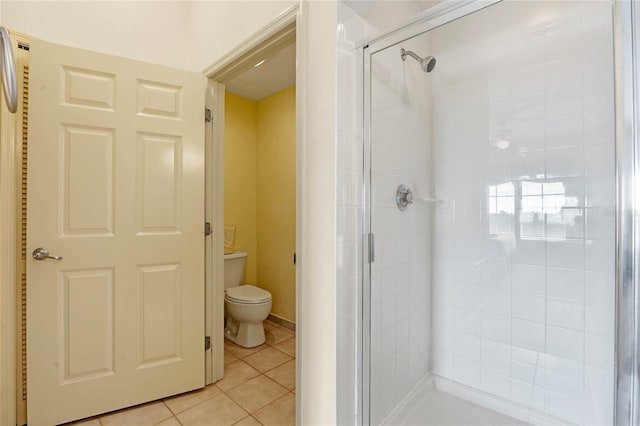 bathroom featuring toilet, tile patterned floors, and an enclosed shower