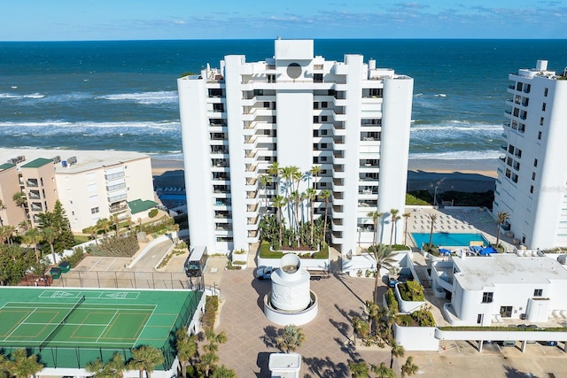 birds eye view of property with a water view and a beach view