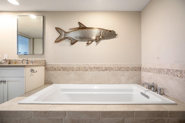 bathroom featuring vanity and tiled bath