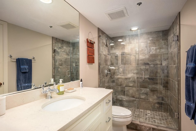 bathroom featuring vanity, an enclosed shower, and toilet