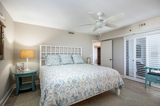 bedroom featuring hardwood / wood-style floors, ceiling fan, and a textured ceiling