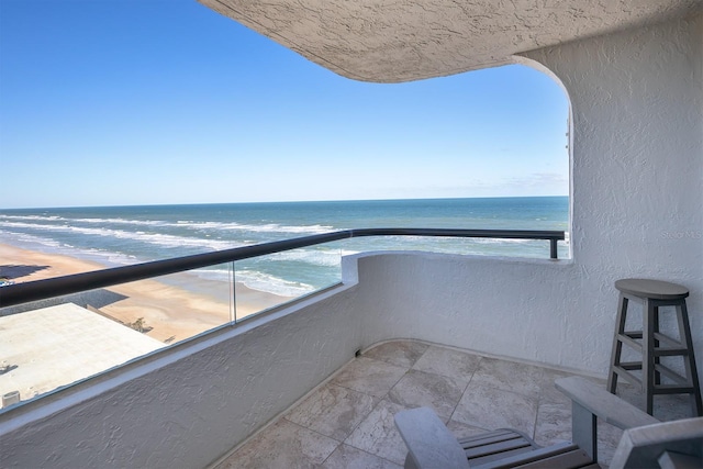 balcony with a water view and a beach view