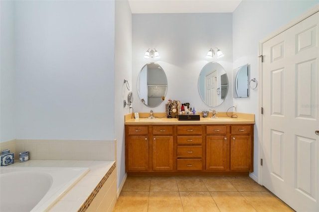 bathroom featuring vanity, a relaxing tiled tub, and tile patterned floors