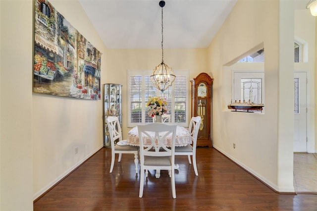 dining room featuring dark hardwood / wood-style flooring, a chandelier, and high vaulted ceiling