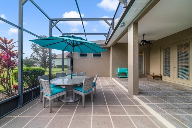 view of patio featuring ceiling fan and glass enclosure