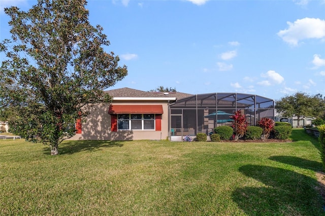 rear view of house with a yard and a lanai