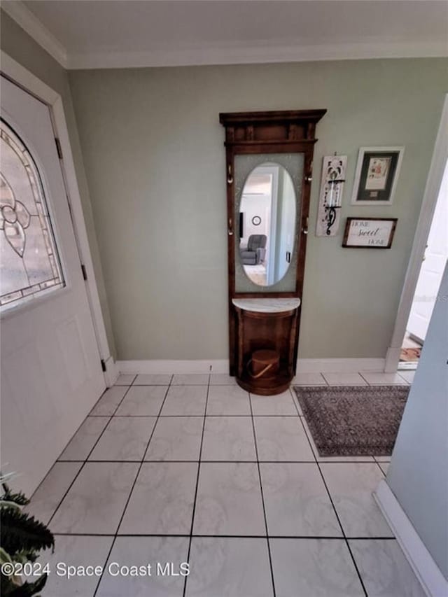 tiled foyer featuring ornamental molding