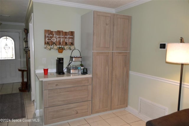 kitchen featuring light tile patterned floors, crown molding, and light brown cabinetry