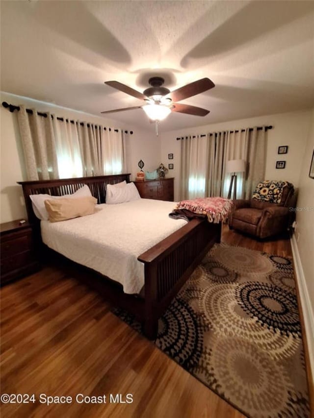 bedroom featuring ceiling fan and dark wood-type flooring