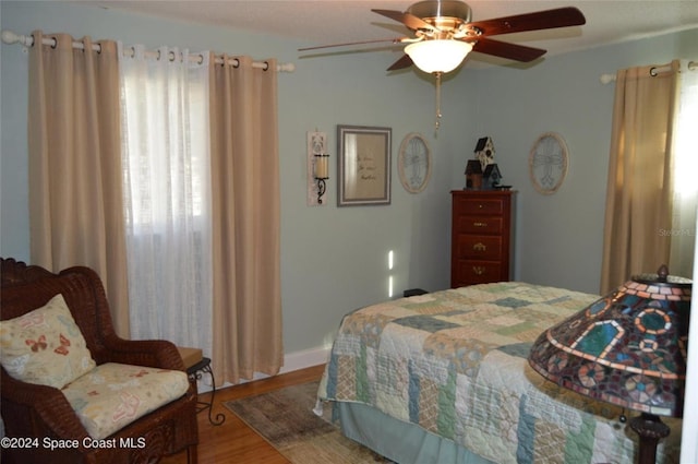 bedroom with ceiling fan and hardwood / wood-style flooring