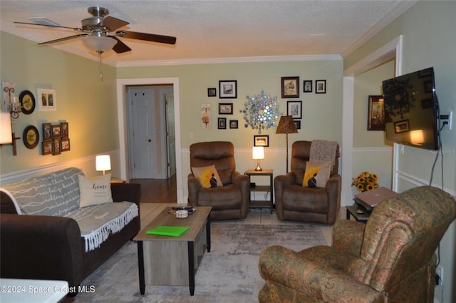 tiled living room with ceiling fan, crown molding, and a textured ceiling