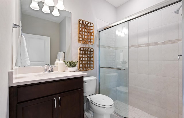 bathroom featuring vanity, an enclosed shower, and toilet