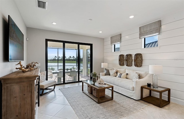 living room featuring wooden walls and light tile patterned floors