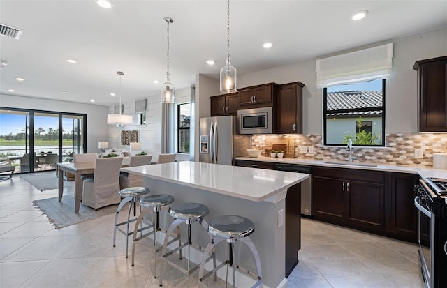 kitchen featuring tasteful backsplash, sink, a center island, and stainless steel appliances