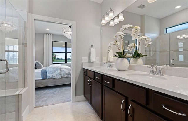 bathroom featuring tile patterned flooring, a wealth of natural light, and a shower with shower door