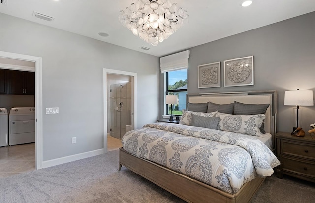 carpeted bedroom featuring washer and dryer, connected bathroom, and a chandelier