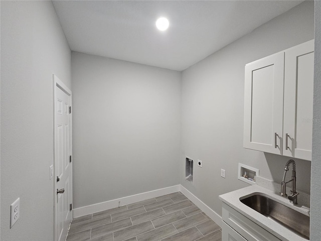 laundry area featuring washer hookup, cabinet space, hookup for an electric dryer, a sink, and baseboards