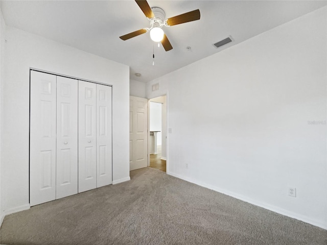 unfurnished bedroom with carpet floors, a closet, and ceiling fan