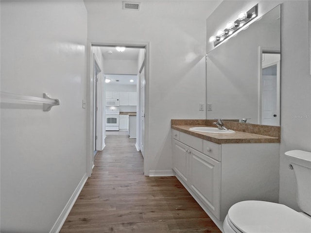 bathroom with vanity, hardwood / wood-style flooring, and toilet