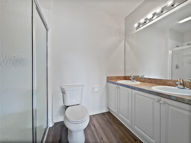 bathroom featuring toilet, hardwood / wood-style floors, vanity, and walk in shower