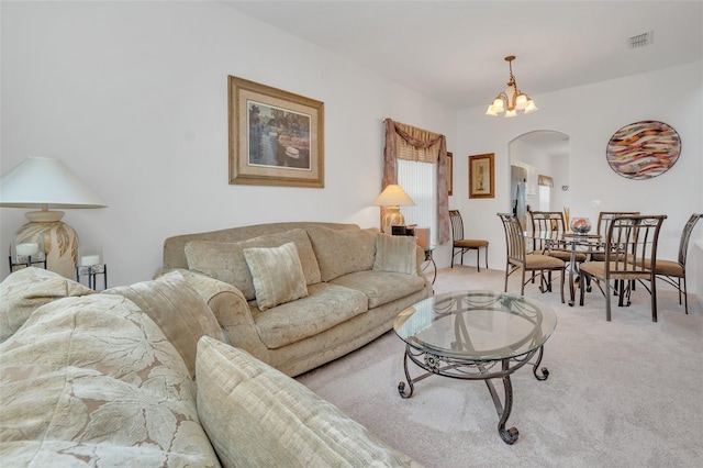 living room with light carpet and a chandelier