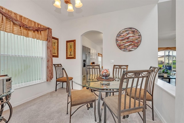 carpeted dining space with a chandelier