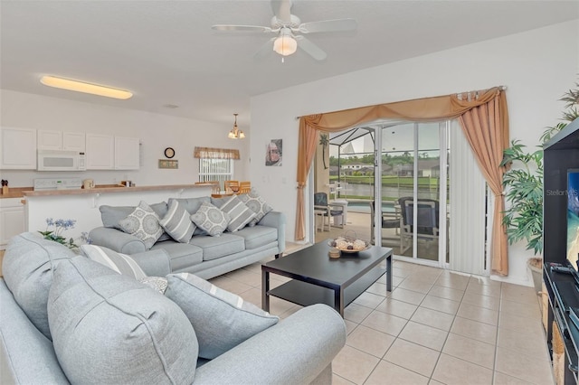 living room featuring light tile patterned floors and ceiling fan with notable chandelier