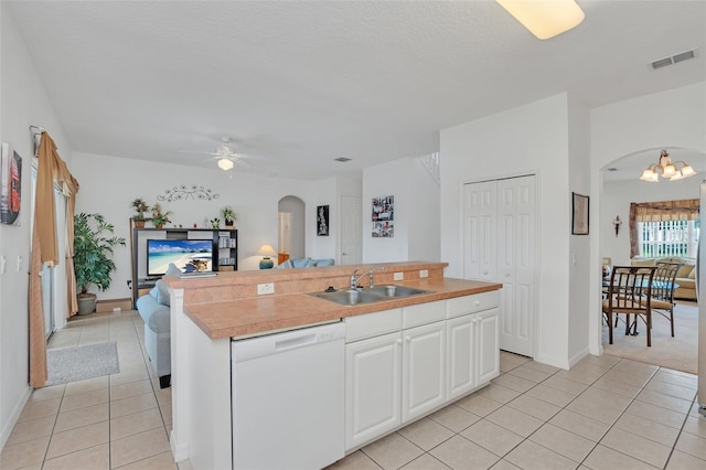 kitchen with white cabinetry, dishwasher, sink, an island with sink, and ceiling fan with notable chandelier