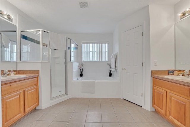 bathroom with tile patterned floors, vanity, and shower with separate bathtub