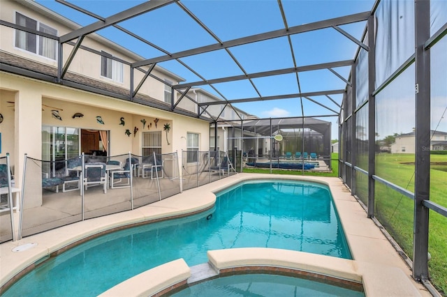 view of pool with glass enclosure and a patio