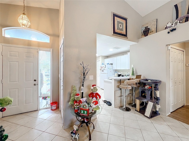 tiled entryway with vaulted ceiling