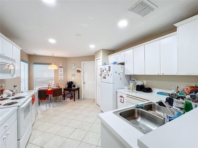 kitchen with white appliances, white cabinetry, hanging light fixtures, and sink